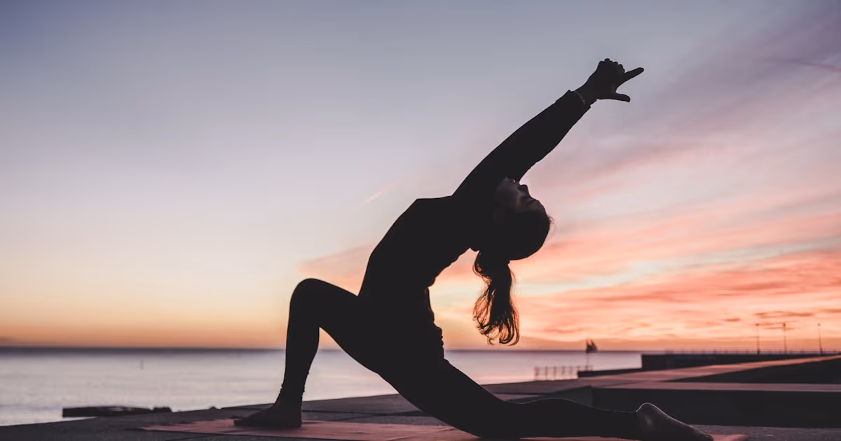 Person practicing somatic shaking exercises on yoga mat for stress relief and nervous system reset